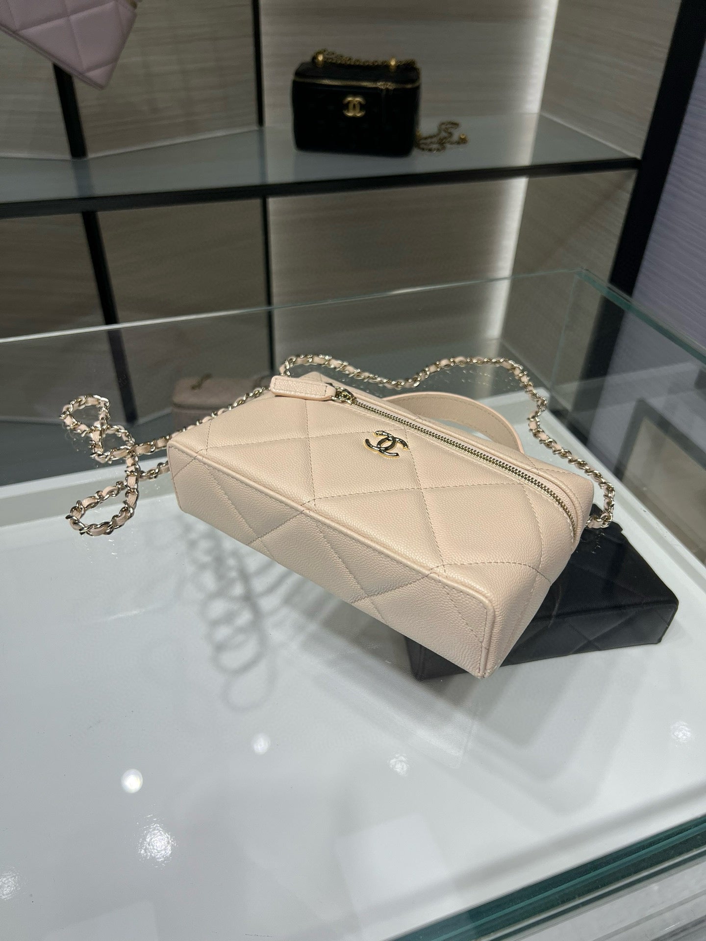 Cream quilted mini shoulder bag with gold chain strap and front zipper pull