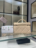 Cream quilted handbag with curved handle, gold chain strap, and front zipper