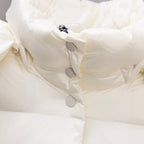 White puffer jacket close-up of front snap buttons and quilted padding