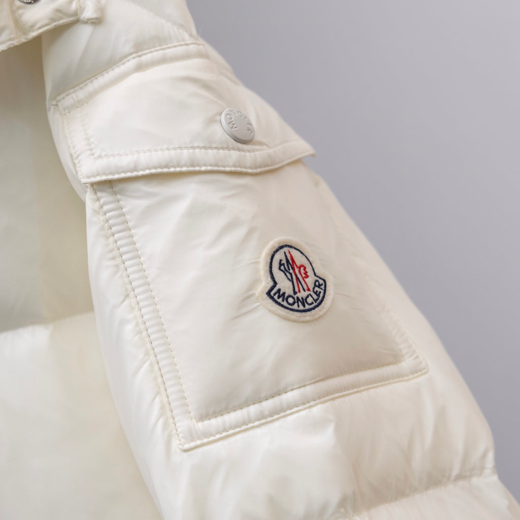 Moncler logo patch on white puffer jacket cuff with stitched edging and snap