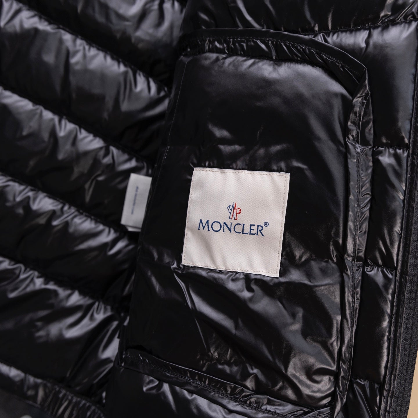 Black puffer jacket fabric label on quilted lining under front flap