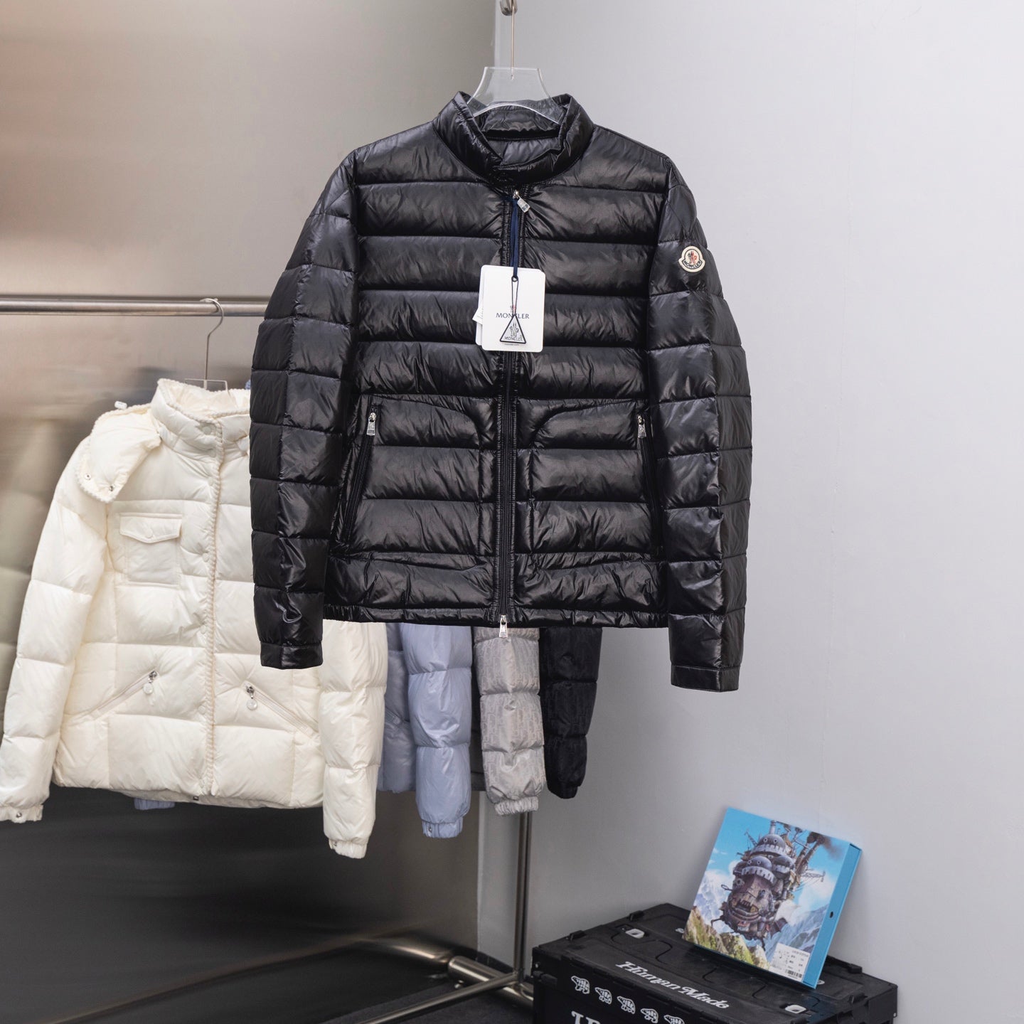 Long black puffer jacket with stand collar, full front zipper, quilted panels