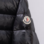 Black puffer jacket sleeve with round embroidered brand patch