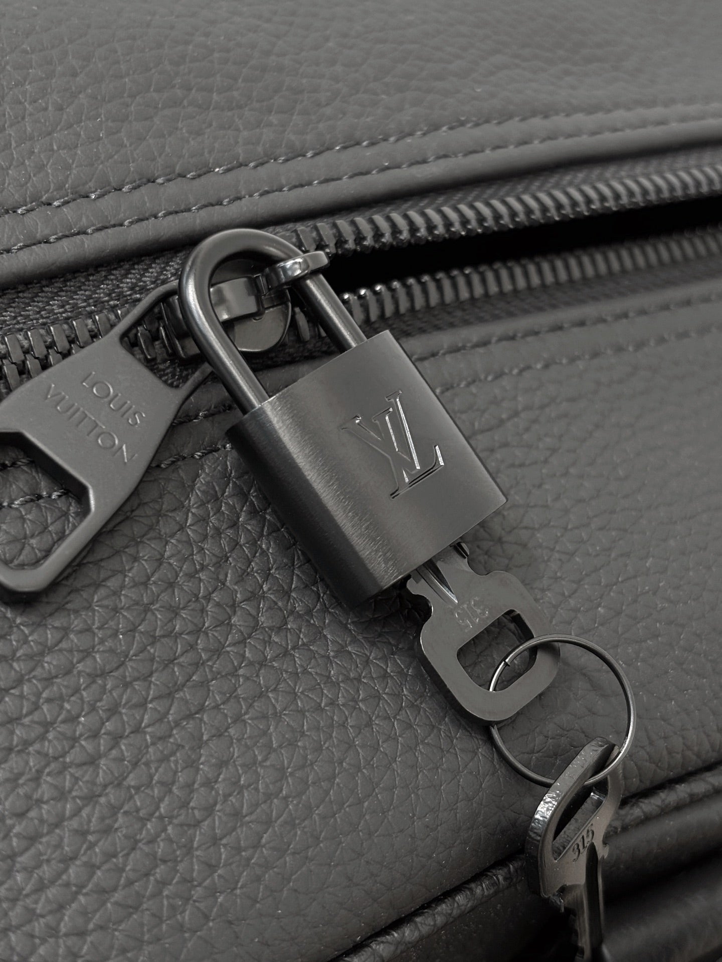 Dark gray leather zipper pull with lock charm and metal ring