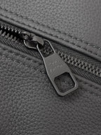 Dark gray leather zipper pull with engraved logo and zipper track