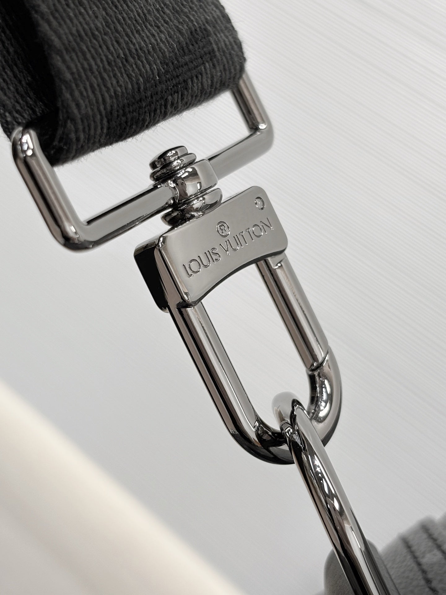 Louis Vuitton shoulder strap hardware close-up with swivel carabiner clip