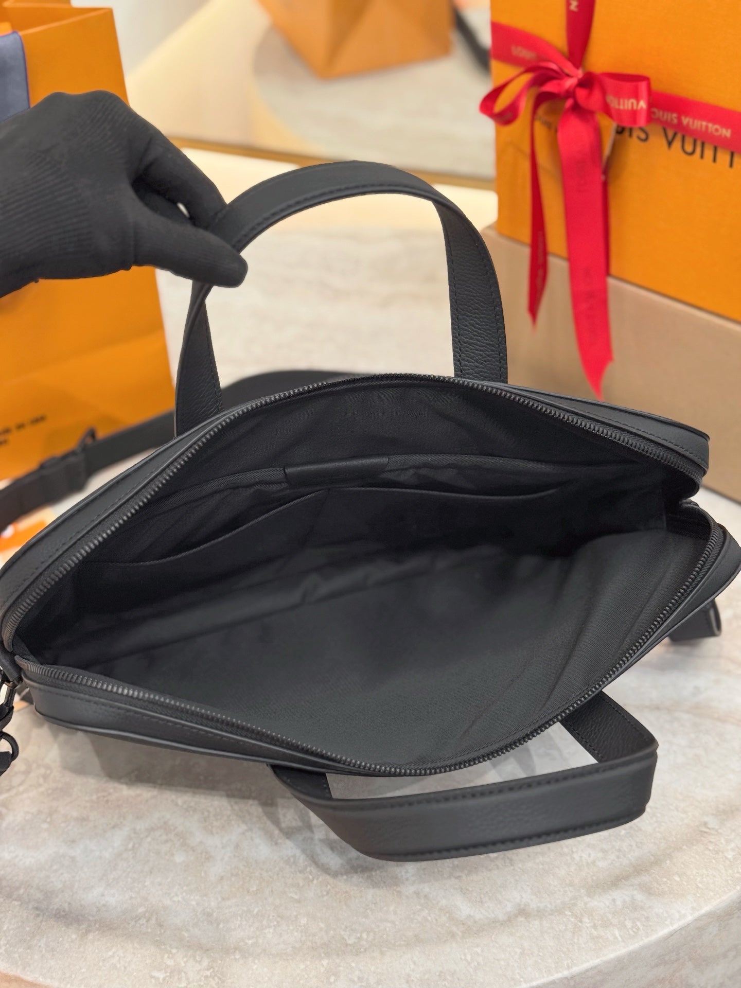 Louis Vuitton men’s leather tote bag, black, open top showing interior lining
