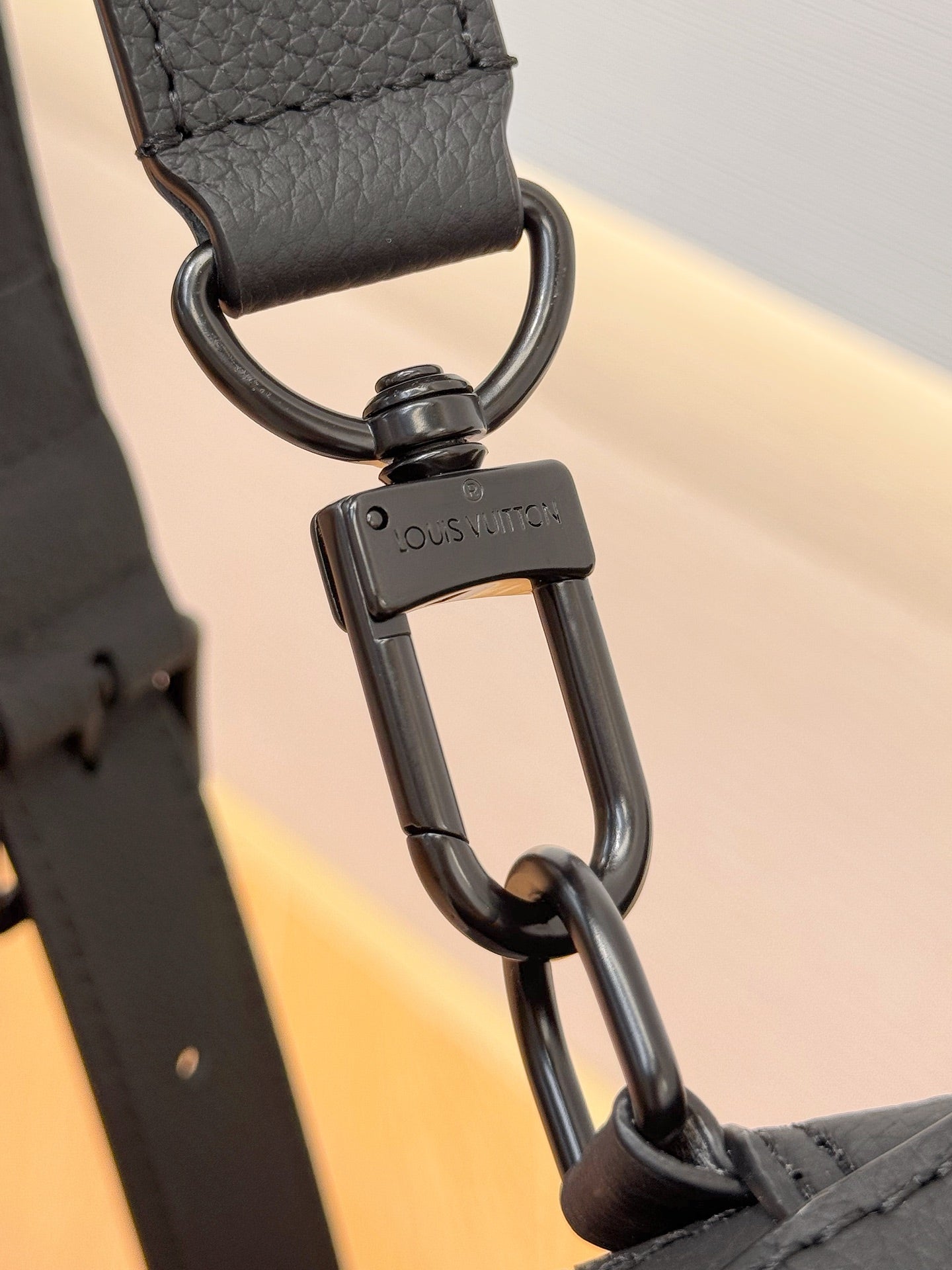 Louis Vuitton black leather strap with metal D-ring hardware and logo tab