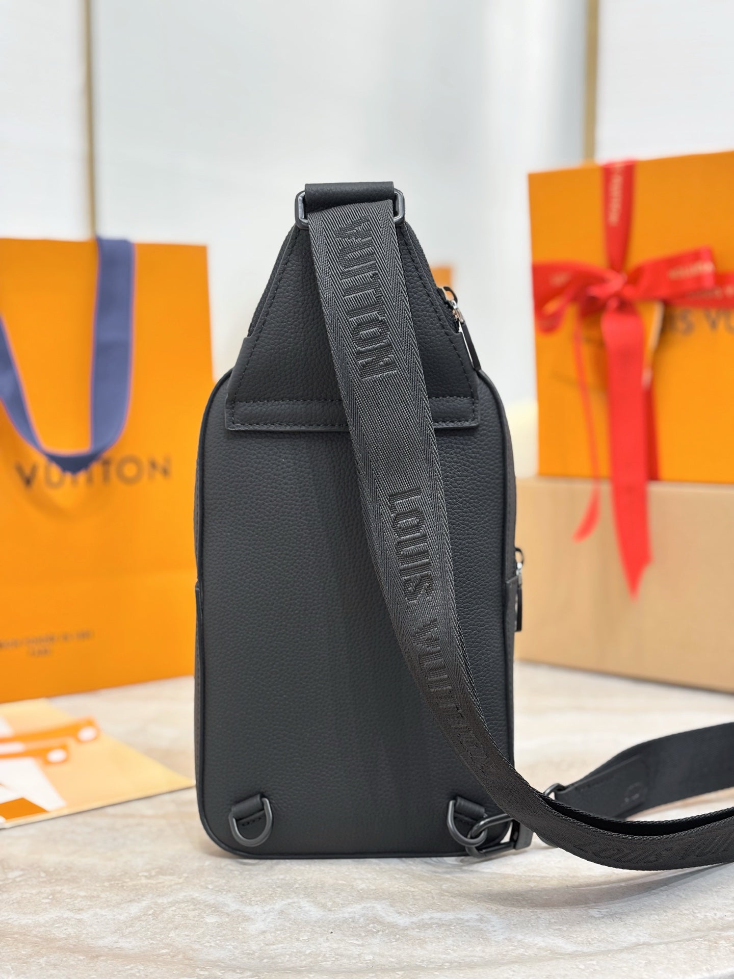 Louis Vuitton black leather crossbody bag, side view with adjustable strap