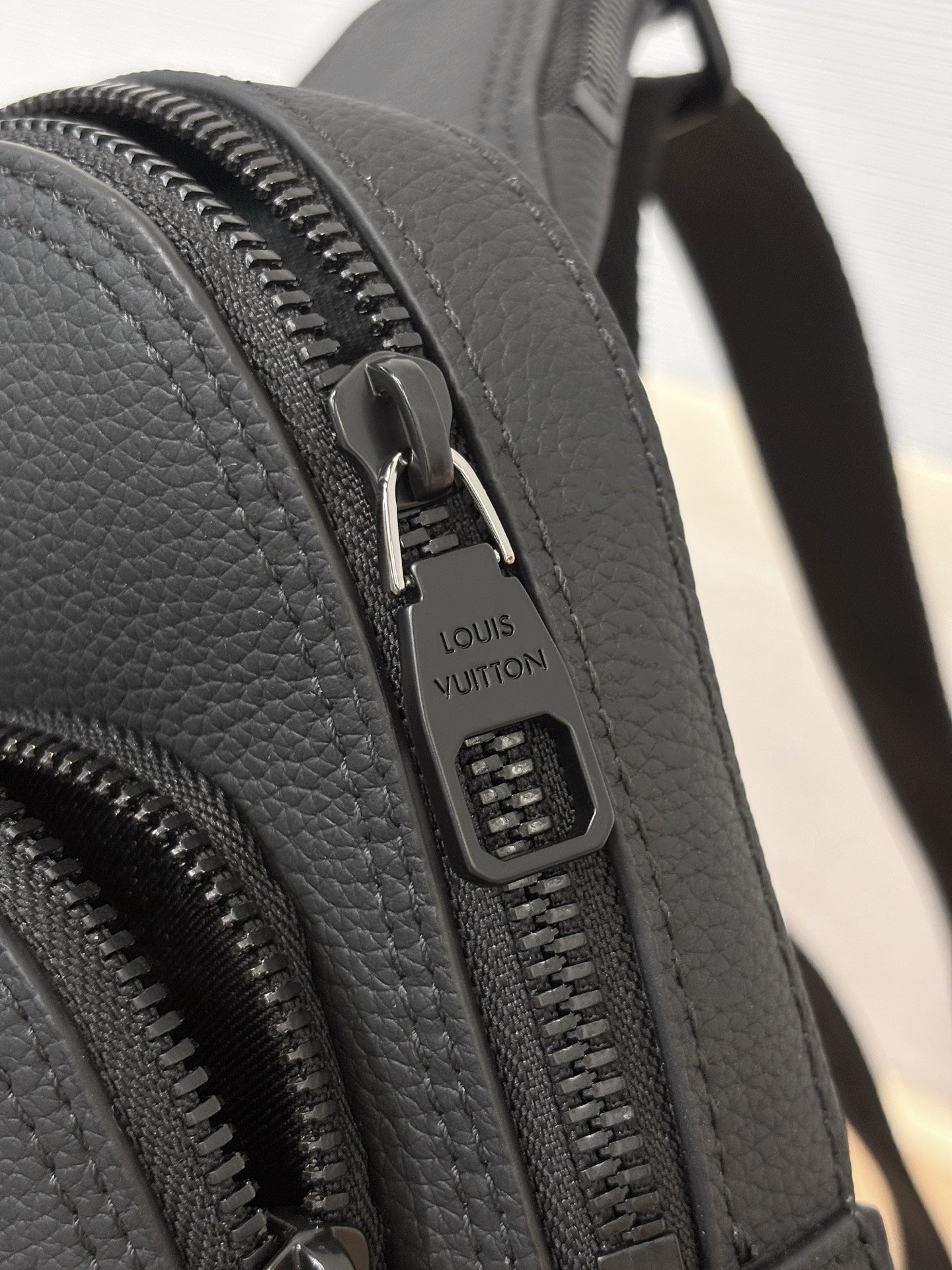 Louis Vuitton black leather bag with engraved zipper pull and track