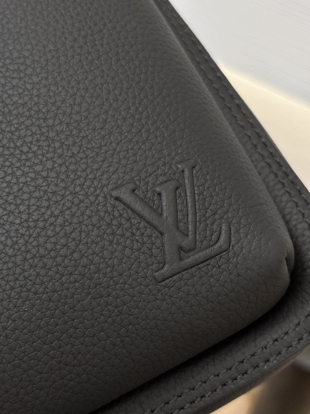 Louis Vuitton black leather corner with embossed LV logo