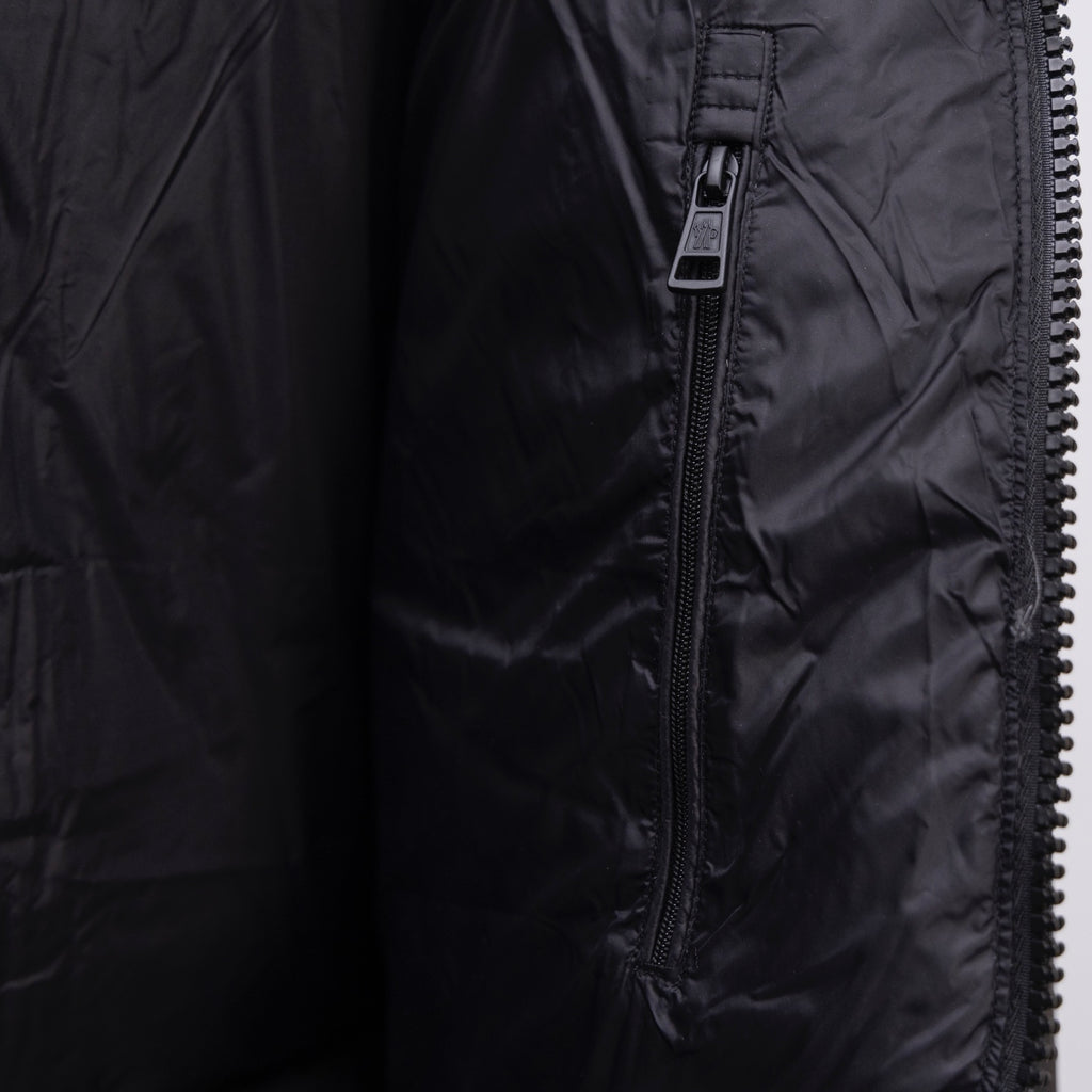 Dark puffer jacket sleeve close-up with zipper and pull tab