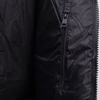 Dark puffer jacket sleeve close-up with zipper and pull tab