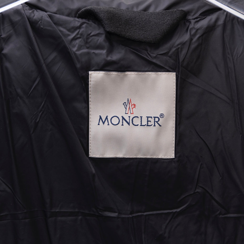 Dark puffer jacket interior with white brand label on fabric lining