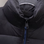 Dark puffer jacket close-up of zip pull with branding tag