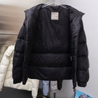 Dark long puffer jacket with hood, zip front, and interior logo patch tag