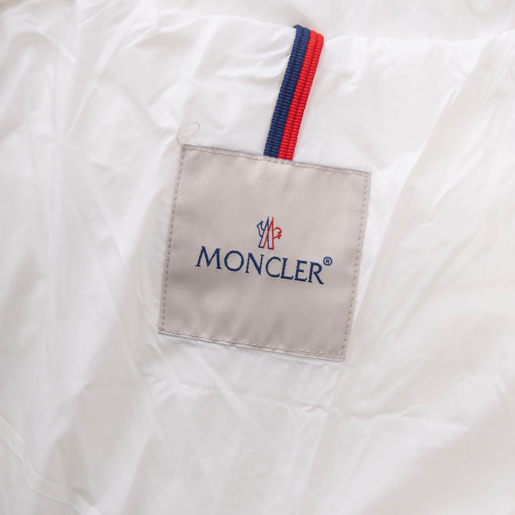 Moncler logo patch with red, white, and blue stripe on white fabric