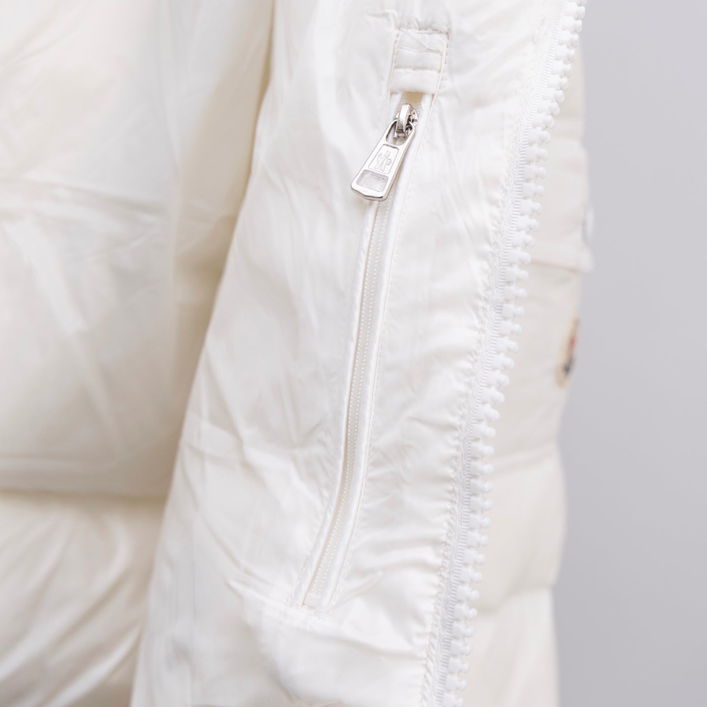 White Moncler puffer jacket front zipper and textured seam stitching