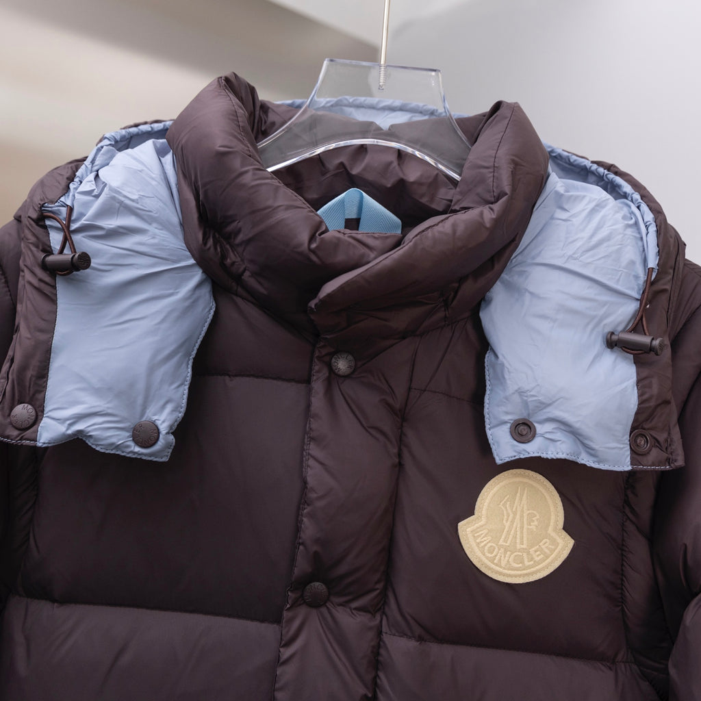Moncler long puffer coat chest detail, dark brown with round gold Moncler logo patch