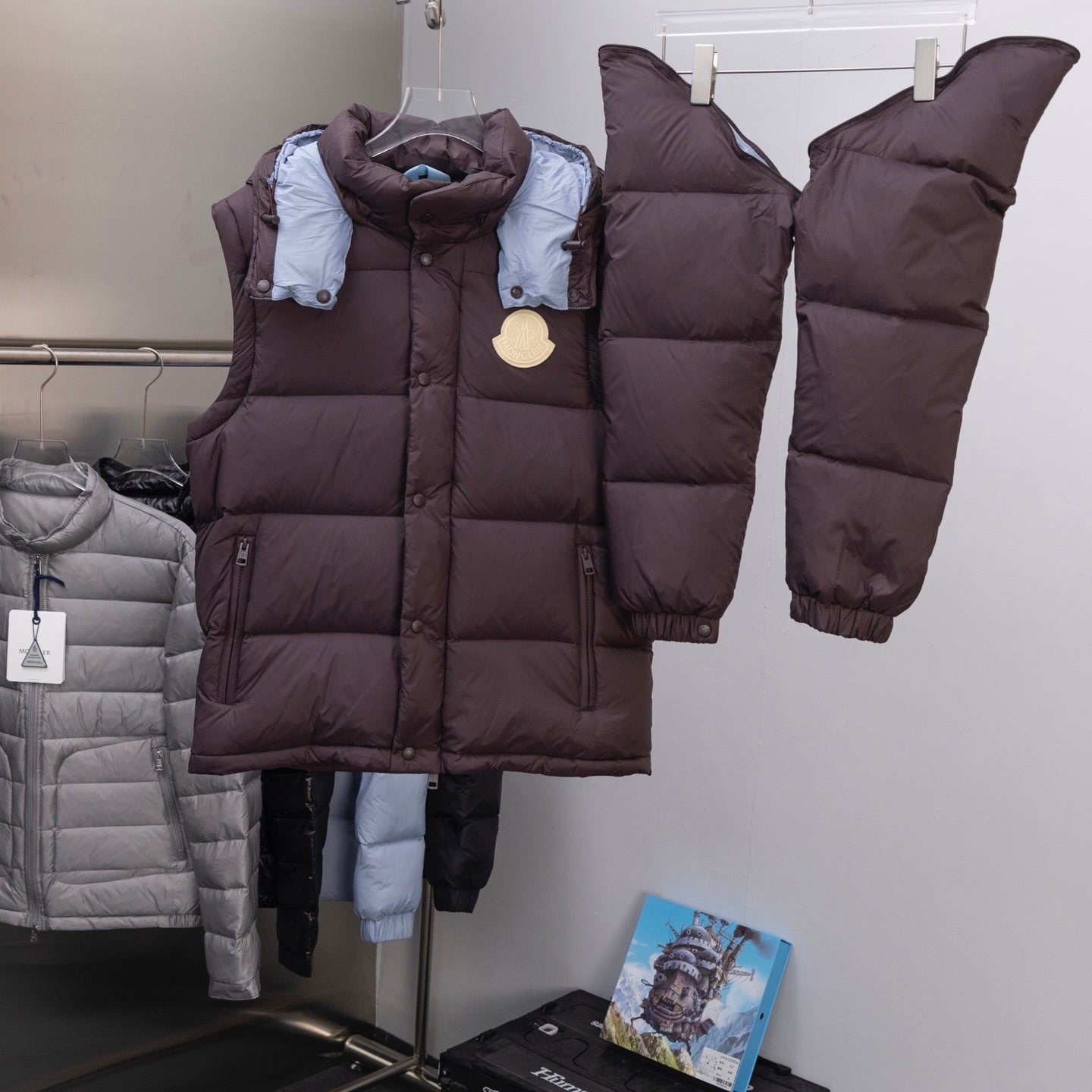Moncler long puffer coat front, dark brown with blue collar lining and logo emblem
