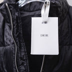 Black Dior puffer jacket with zipper and hanging Dior retail tag.