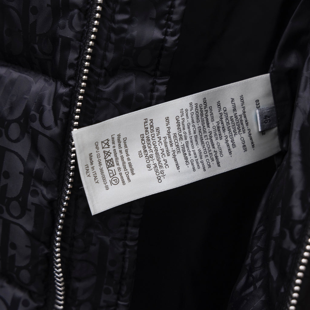 Black Dior puffer jacket care label tag near front zipper.