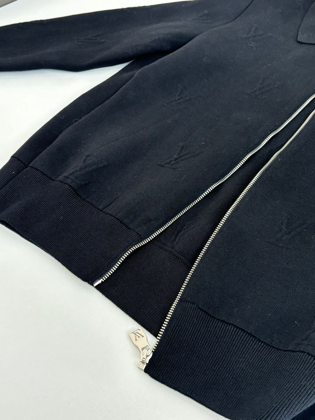 Dark navy zip-up jacket front with silver zipper and ribbed trim detailing