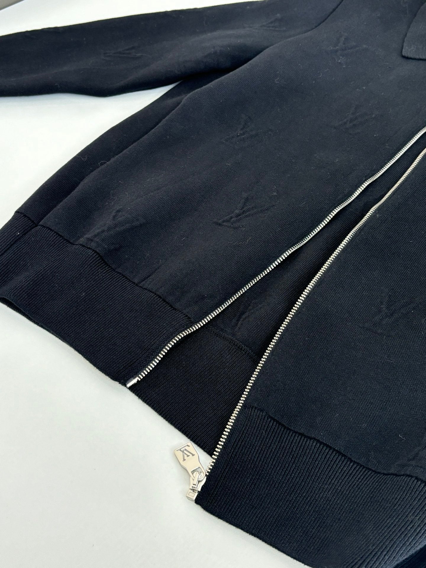 Dark navy zip-up jacket front with silver zipper and ribbed trim detailing