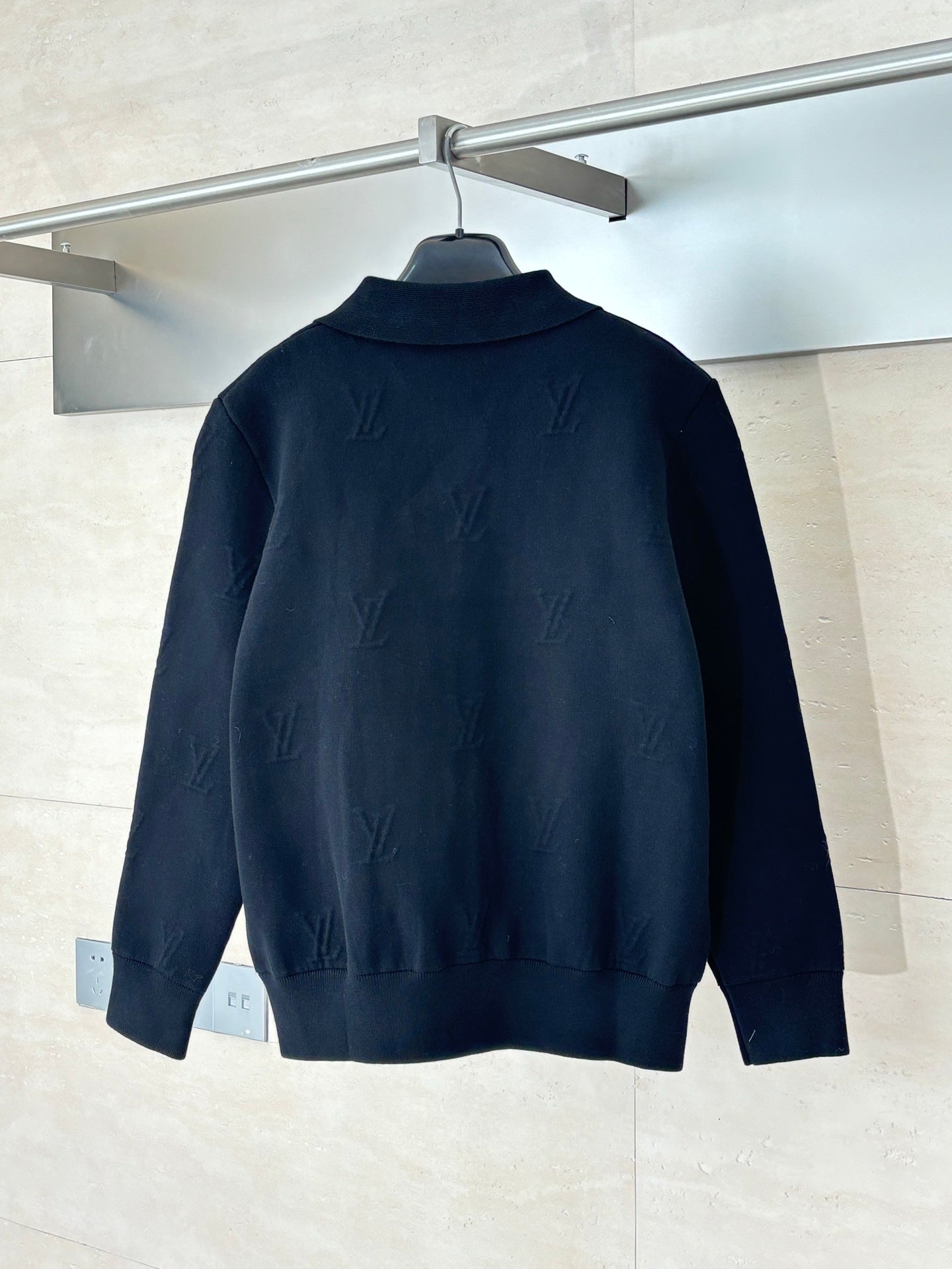 Dark navy zip-up jacket with point collar and subtle monogram pattern