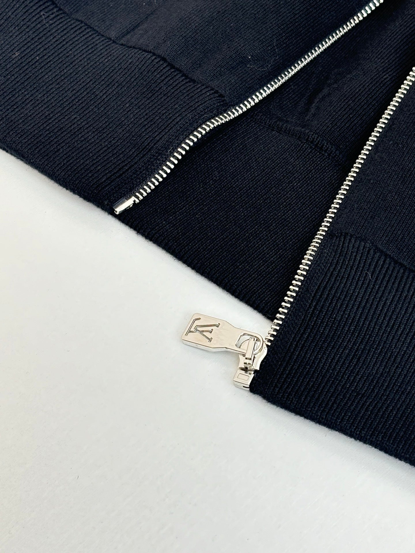 Dark navy knit jacket zipper pull and silver-tone zipper hardware