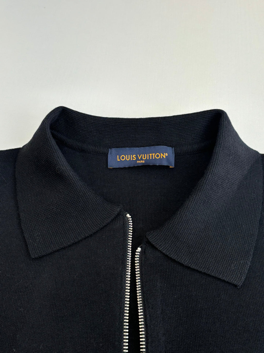 Dark navy zip-up jacket neckline with point collar and partial zipper