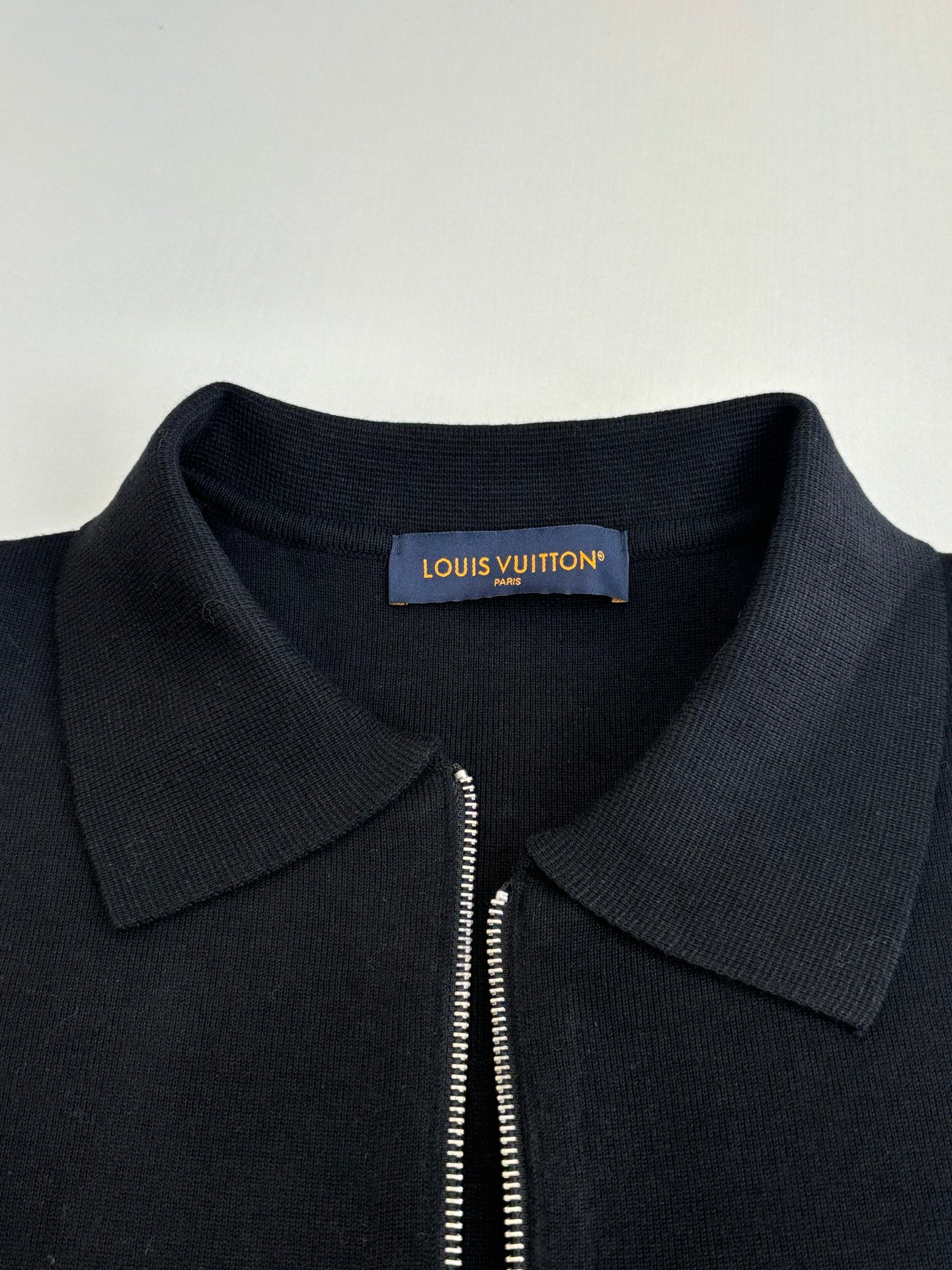 Dark navy zip-up jacket neckline with point collar and partial zipper