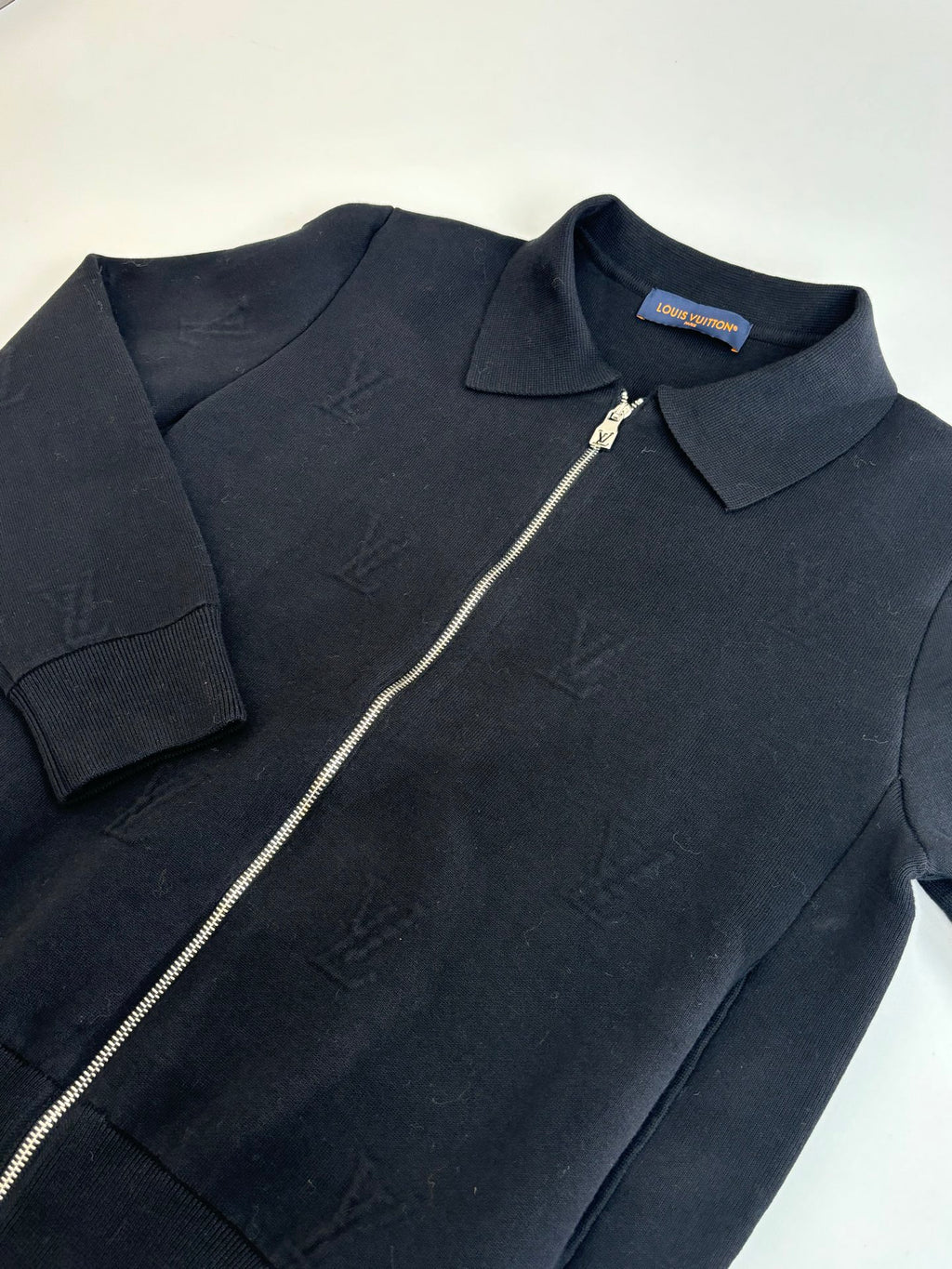 Dark navy zip-up jacket top section with point collar and silver zipper pull