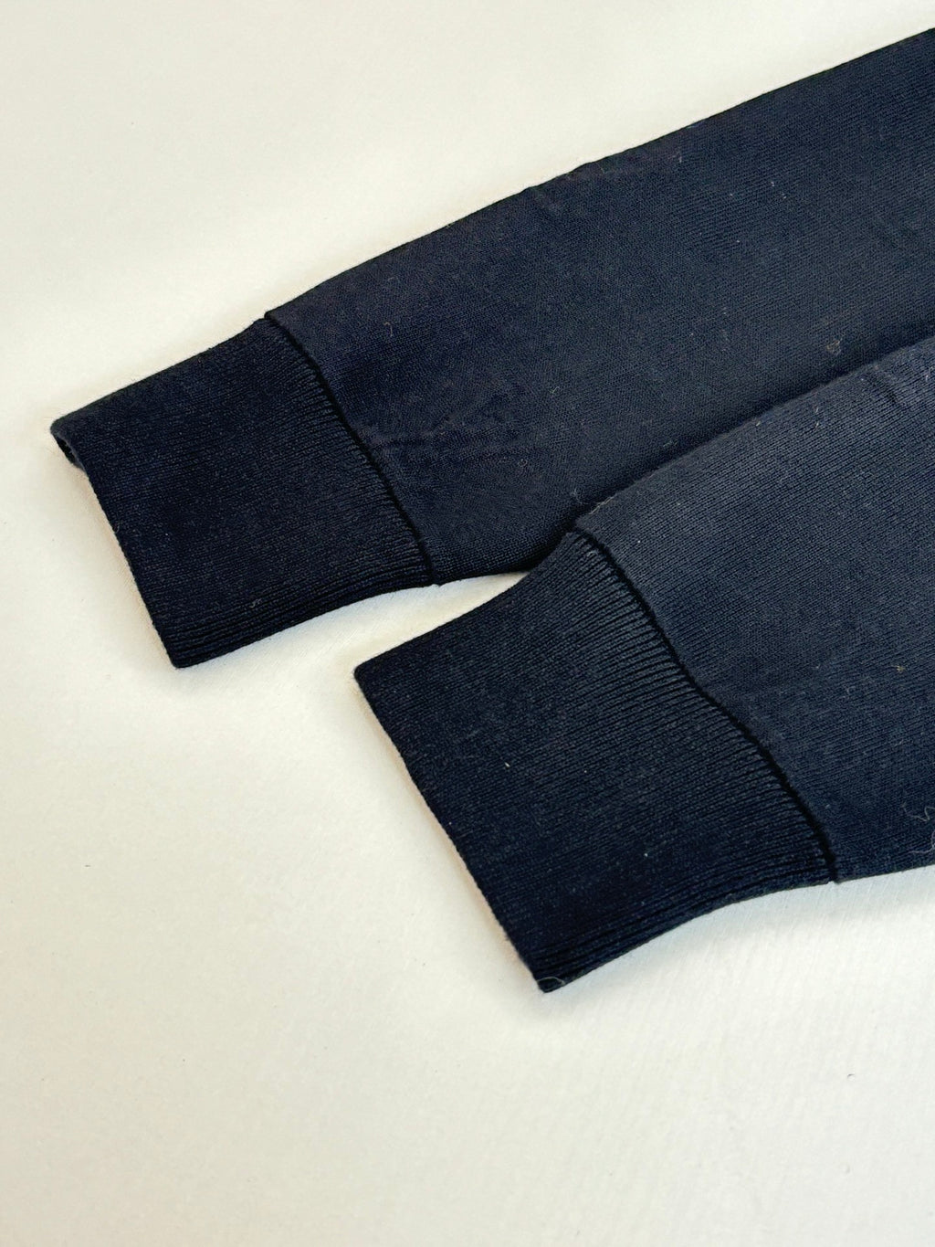 Dark navy knit jacket sleeves and ribbed cuffs, laid flat