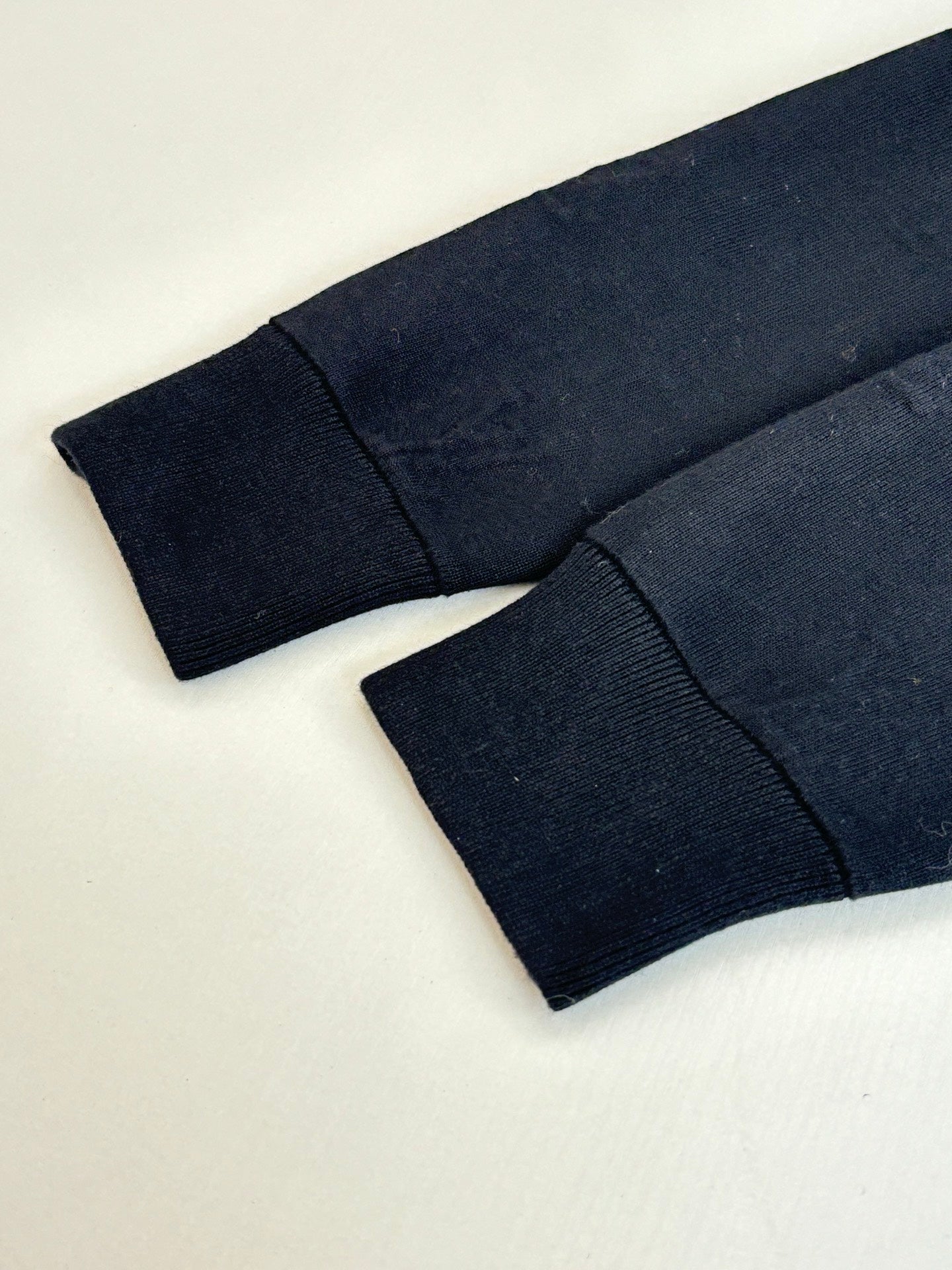 Dark navy knit jacket sleeves and ribbed cuffs, laid flat