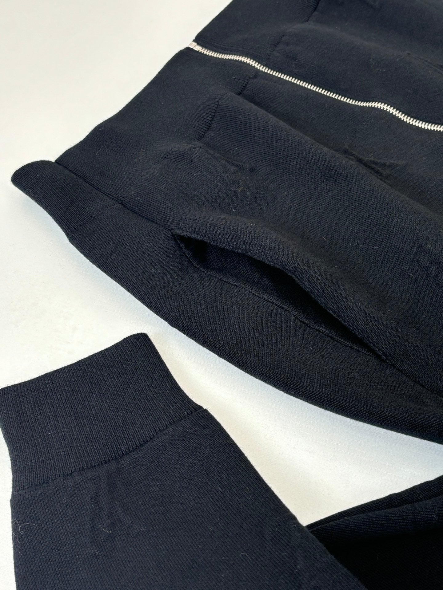Dark navy knit jacket front panels with ribbed hem and zipper at top edge
