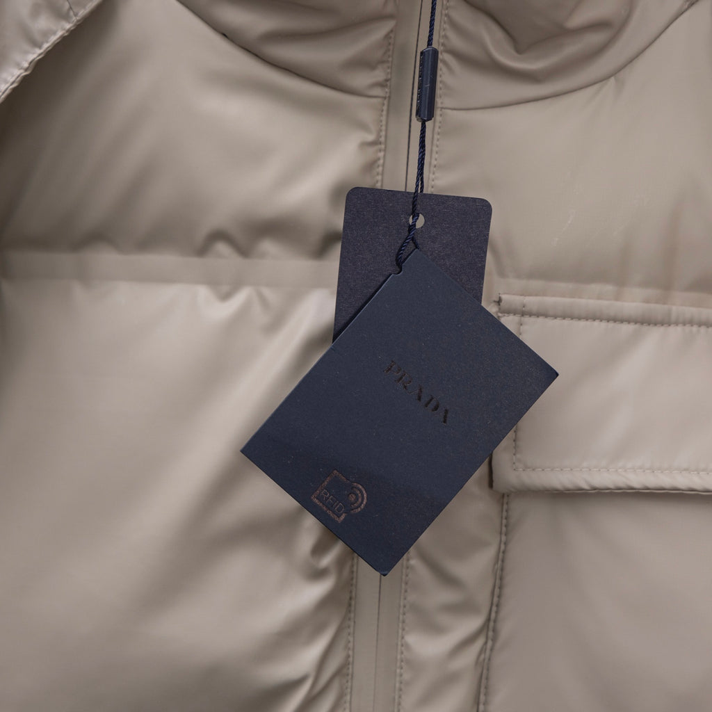 Prada puffer jacket close-up of vertical zipper and hanging brand tag