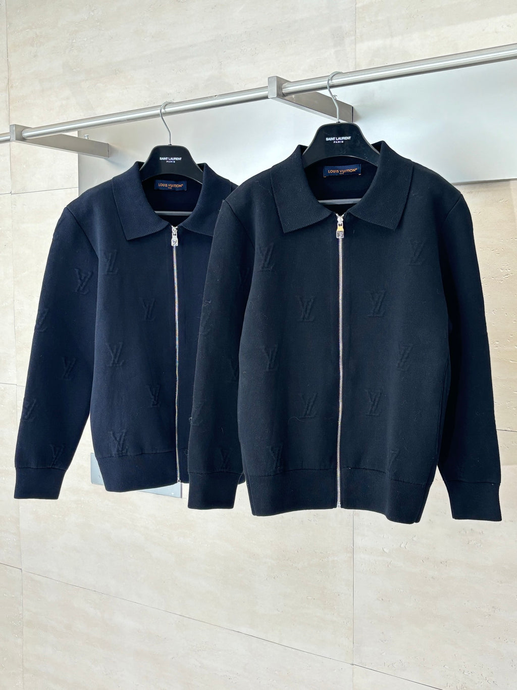 Two dark navy zip-up jackets on hangers, point collar and full-length zipper