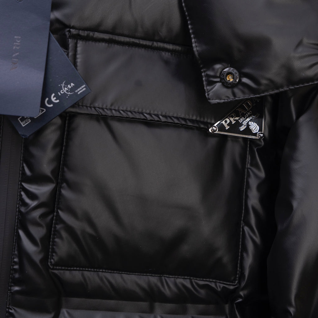 Long puffer jacket chest pocket with Prada-stamped metal tab