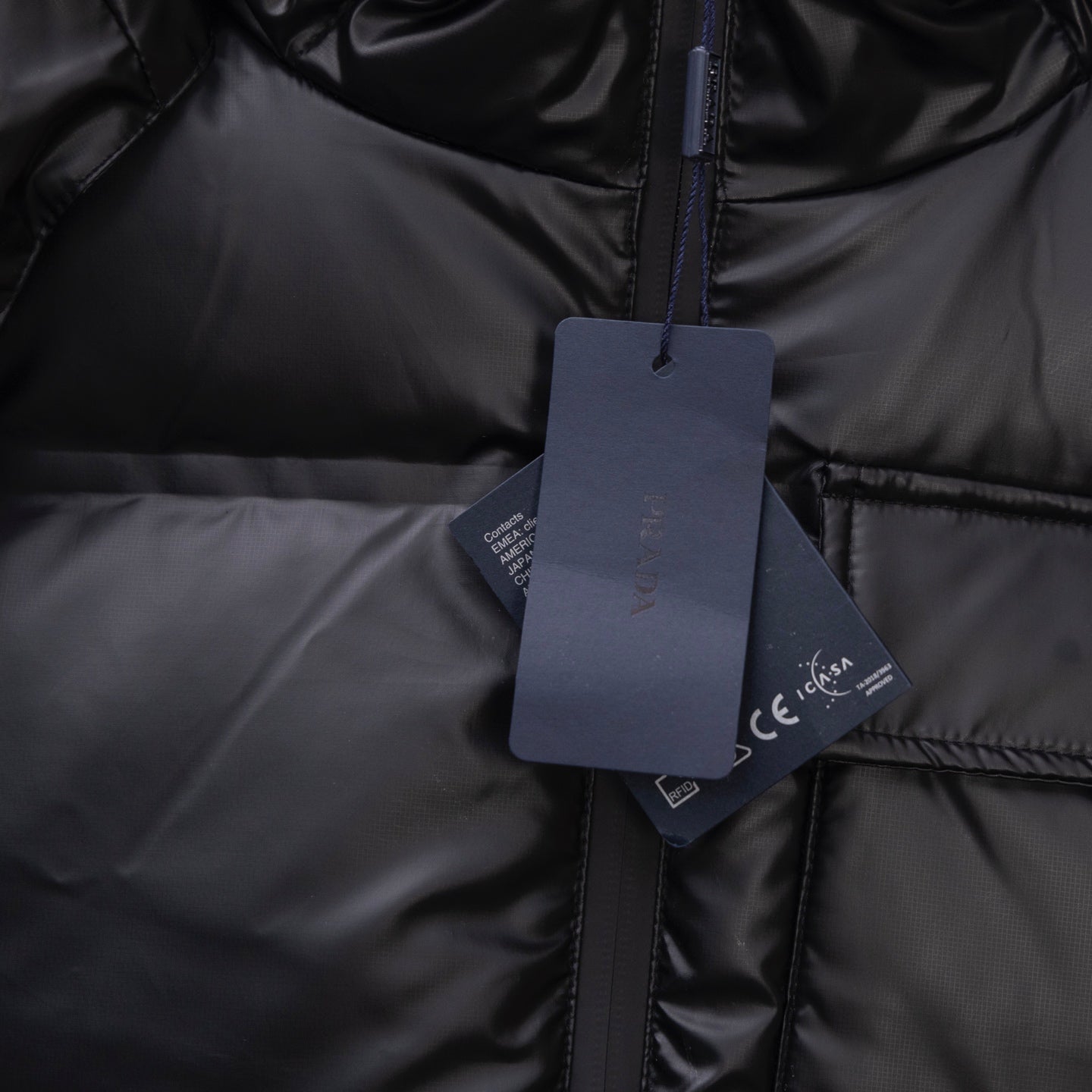 Long puffer jacket, dark front zip with hanging product tag