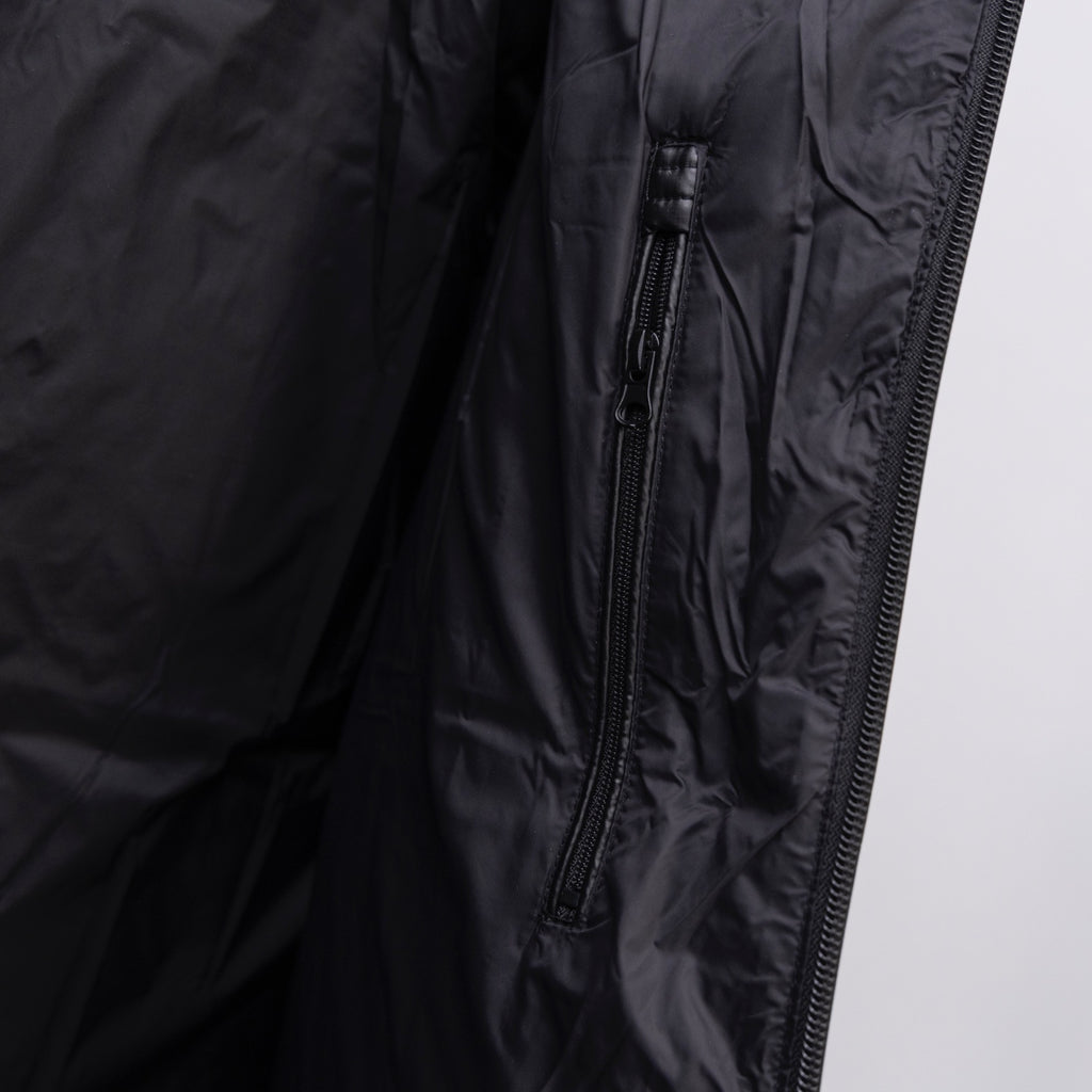 Long puffer jacket close-up of front side zipper on dark fabric