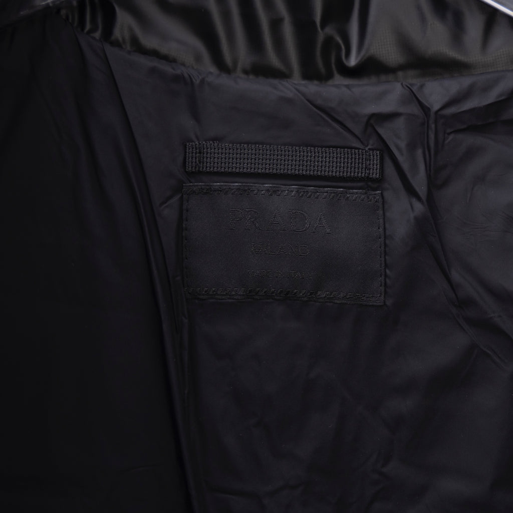 Long puffer jacket pocket patch detail on dark fabric