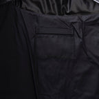 Long puffer jacket pocket patch detail on dark fabric