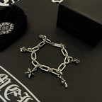 Silver tone charm bracelet with dangling flower charms and star cross on chain links