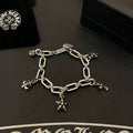 Silver tone charm bracelet with linked chain and star cross and flower charms