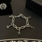 Silver tone charm bracelet with linked chain and star cross and flower charms