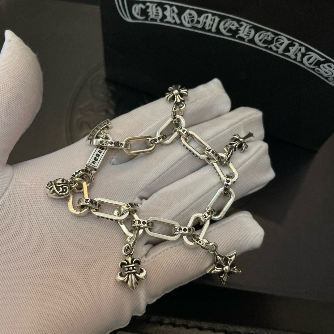 Silver tone charm bracelet close-up with chunky links and star and flower pendants