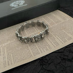 Silver-tone bracelet with engraved rectangular links and floral charms, top view