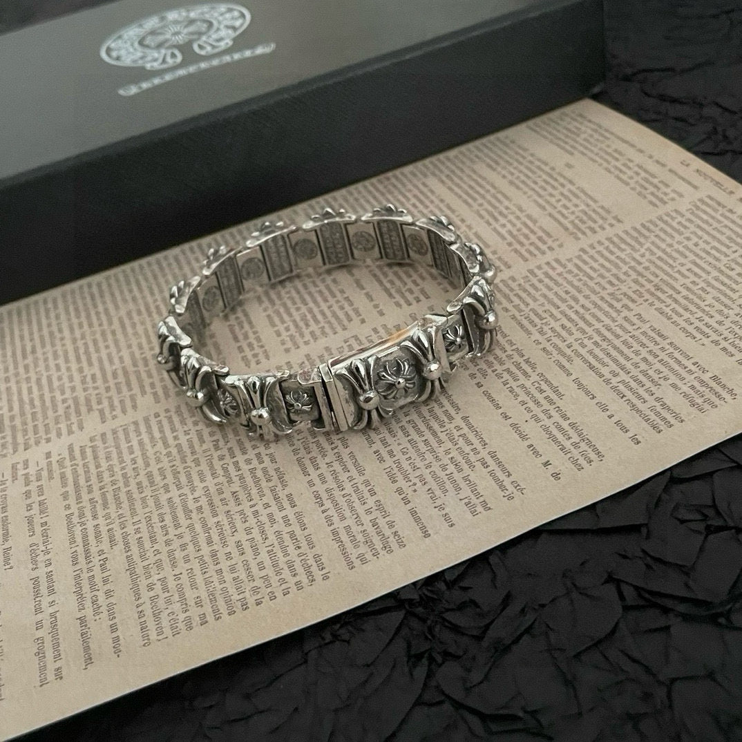 Silver-tone bracelet with engraved rectangular links and floral charms, top view