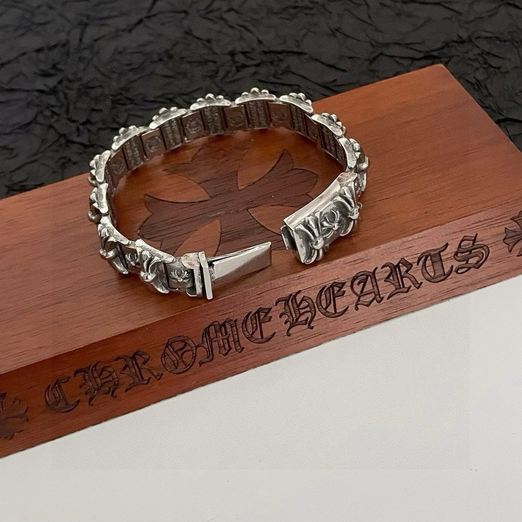 Silver-tone engraved bracelet with floral corner details and a pointed bar clasp